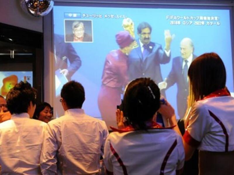Japanese soccer fans watch television on Qatar's Emir being congratulated by FIFA President Sepp Blatter after they were announced as the 2022 World Cup host country at "M-SPO" sports bar in Tokyo.