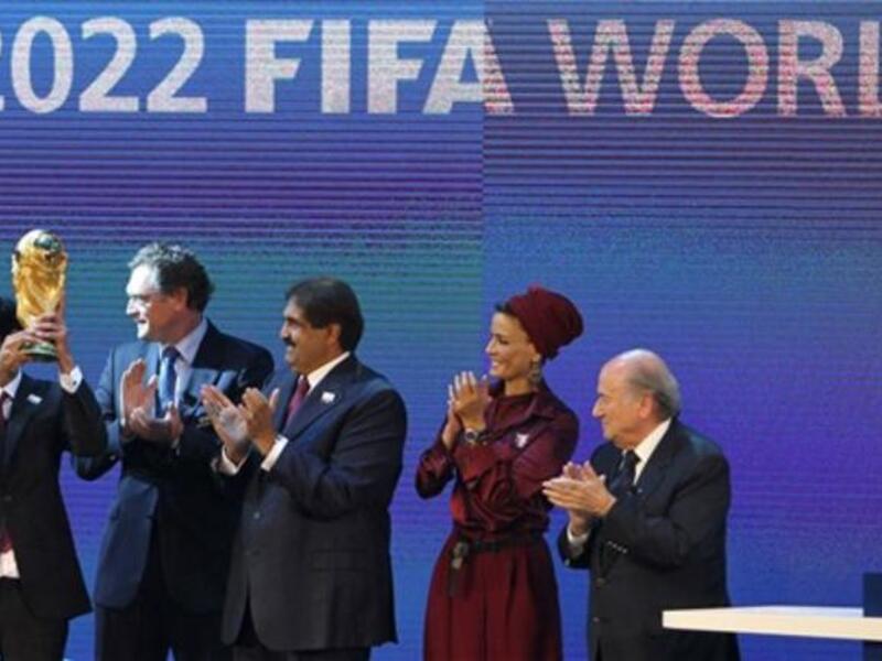 Sheikh Mohammed bin Hamad al-Thani, chairman of the Qatar 2022 bid committee, (L) raises the World Cup trophy as he stands with Qatar's Emir Sheikh Hamad bin Khalifa al-Thani (C), his wife Sheikha Moza and FIFA president Joseph Blatter (R).