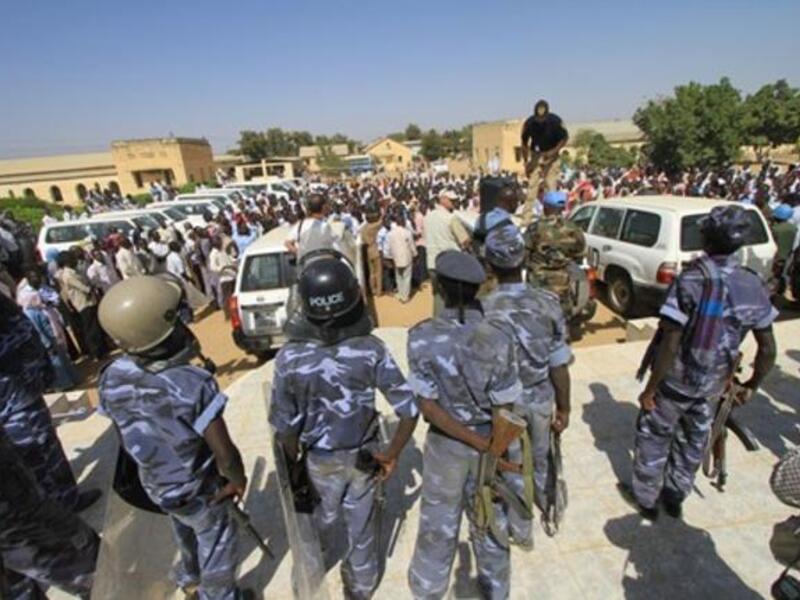 Sudanese policemen stand guard as university students gather during a protest against the visit of Darfur mediators from Qatar and the UN outside the University of Zalingei in western Darfur.