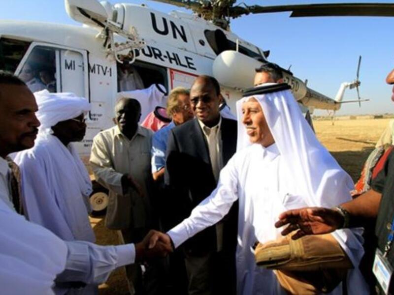 Djibril Bassole, chief negotiator for the UN and the African Union, and Qatari Minister of State for Foreign Affairs Ahmed bin Abdullah al-Mahmud are greeted by local Sudanese.