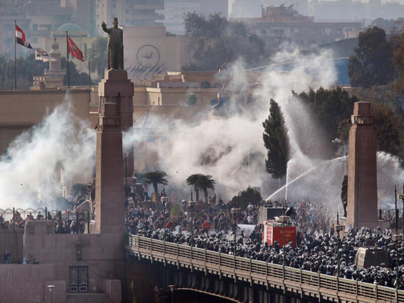 Riot police force protesters back across the Kasr Al Nile Bridge as they attempt to get into Tahrir Square in downtown Cairo, Egypt.