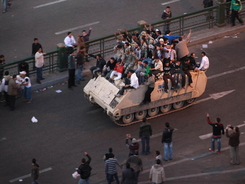 Protesters ride an armored personnel carrier towards the Nile.