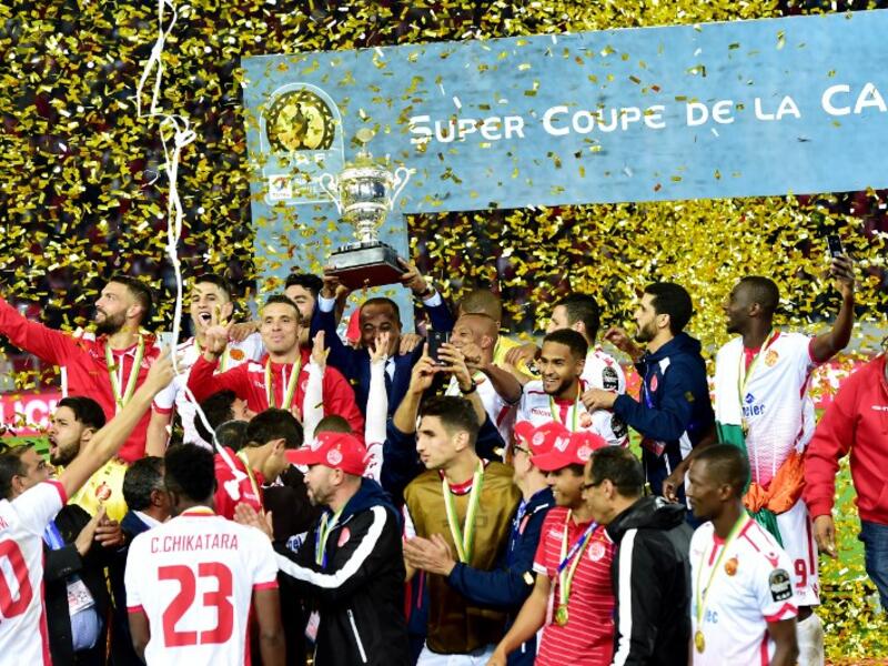 Wydad Casablanca's players celebrate with the champions' trophy after winning the 2018 Total CAF Super Cup match against TP Mazembe, at the Mohammed V Stadium in Casablanca on February 24, 2018.
STRINGER / AFP