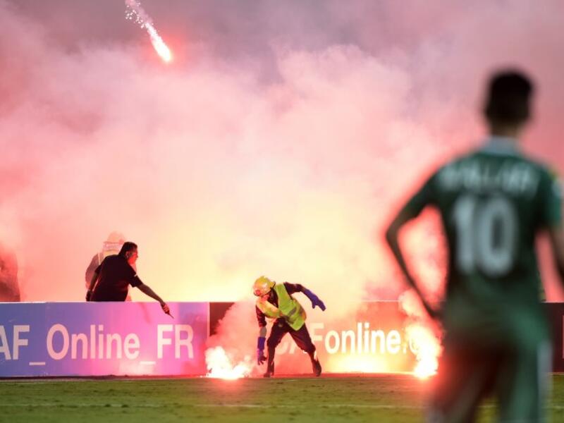 رجل أمن يعمل على إطفاء أحد المقذوفات خلال مباراة الزمالك المصري وأهلي طرابلس الليبي على ملعب برج العرب في الاسكندرية ضمن دوري أبطال إفريقيا.