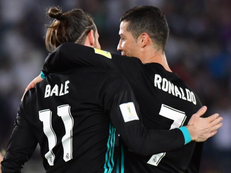 Real Madrid's Welsh forward Gareth Bale (L) is congratulated after scoring by teammate Portuguese forward Cristiano Ronaldo (R) during the FIFA Club World Cup semi-final match in the Emirati capital Abu Dhabi on December 13, 2017.
GIUSEPPE CACACE / AFP