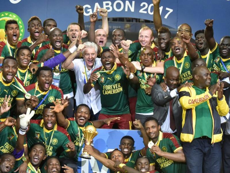 Cameroon team players and Cameroon's Belgian coach Hugo Broos (C) celebrate with the winner's trophy after beating Egypt 2-1 to win the 2017 Africa Cup of Nations final football match between Egypt and Cameroon at the Stade de l'Amitie Sino-Gabonaise in Libreville on February 5, 2017.
ISSOUF SANOGO / AFP