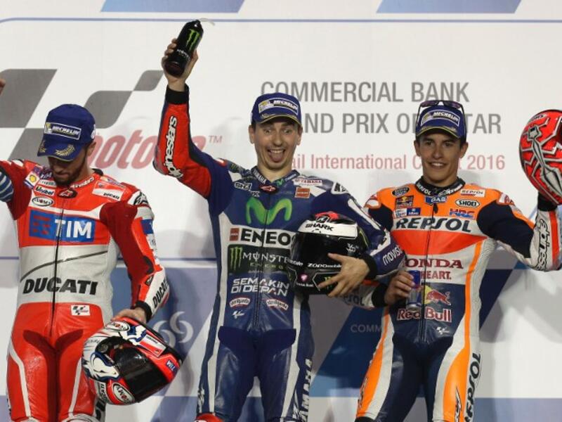 Spanish MotoGP rider Jorge Lorenzo (C) of the Movistar Yamaha MotoGP team celebrates on the podium after winning the Qatar MotoGP race with Italian rider Andrea Dovizioso (L) of the Ducati Team who won second place and Spanish rider Marc Marquez (R) third place at the Losail International Circuit in Doha on March 20, 2016.
KARIM JAAFAR / AFP