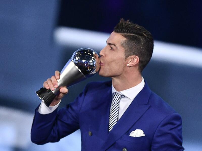 Real Madrid and Portugal's forward Cristiano Ronaldo kisses his trophy after winning the The Best FIFA Men’s Player of 2016 Award next to FIFA president Gianni Infantino during The Best FIFA Football Awards ceremony, on January 9, 2017 in Zurich.
Fabrice COFFRINI / AFP