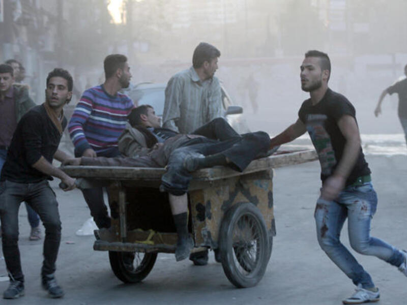 Two injured men are transported on a fruit barrow in the Syria, following a shelling. (Image credit: AFP)