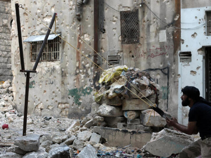 A Syrian opposition fighter aims fire with a catapult towards regime forces in the northern embattled Syrian city of Aleppo. (Image credit: AFP)