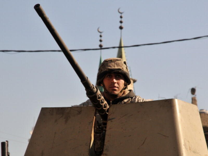 A Lebanese army soldier patrols a street with an armoured vehicle in the northern Lebanese city of Tripoli on October 29, 2013. [IBRAHIM CHALHOUB/Getty Images]