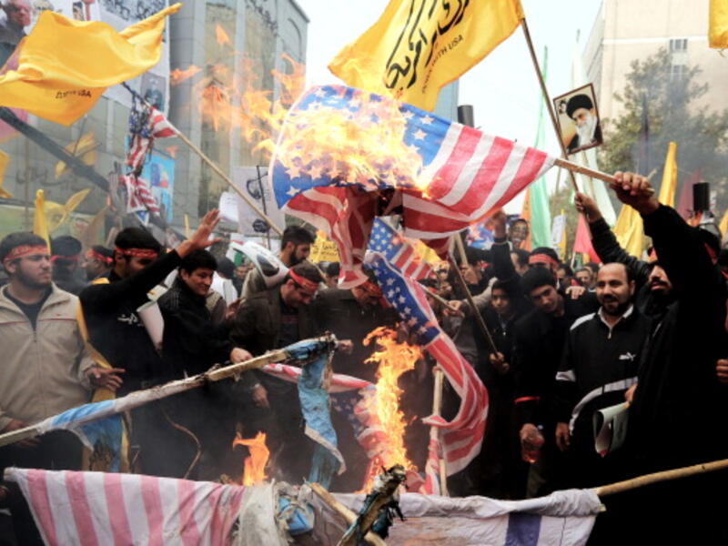 Iranians burn US flags outside the former US embassy in Tehran on November 4, 2013, during a demonstration to mark the 34th anniversary of the 1979 US embassy takeover. [Getty Images]