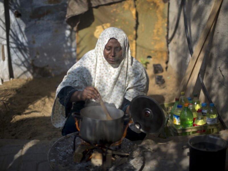 A Palestinian woman cooks her food on fire wood in Biet Hanun northern Gaza Strip, on November 19, 2013, due to the shortage in butane gas across the Hamas run Palestinian territory. [AFP]