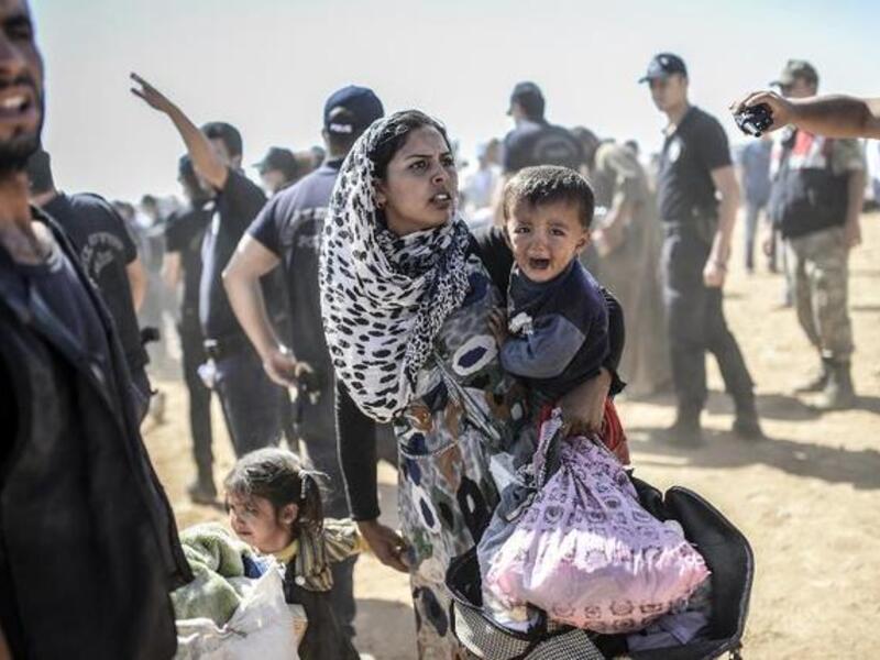 A Syrian Kurdish woman crosses the border between Syria and Turkey at the southeastern town of Suruc in Sanliurfa province on September 23, 2014.  (AFP/Bulent Kilic)