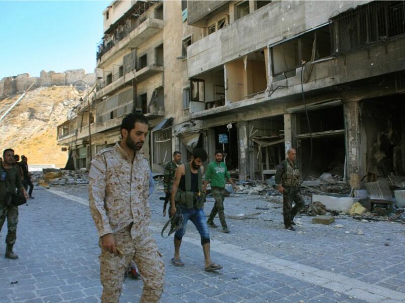 Syrian pro-government forces are seen on September 28, 2016 in the Farafira district, northwest of Aleppo's historic citadel. Syria's army took control of the rebel-held district after days of heavy air strikes that sparked allegations of war crimes. (AFP/Georges Ourfalian)