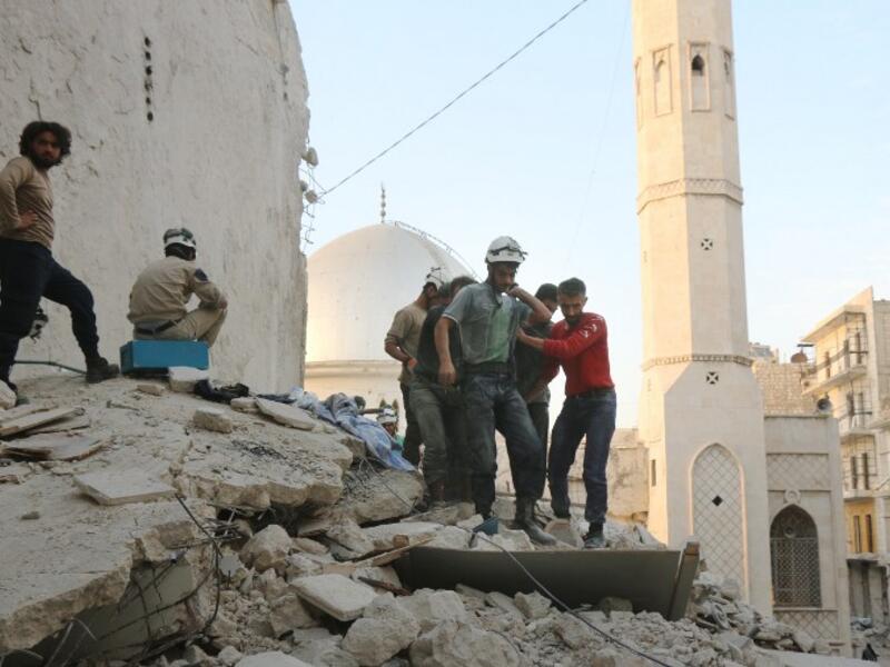Syrian civil defense volunteers, known as the White Helmets, carry the body of a victim following a government forces air strike on the rebel-held neighborhood of Bustan al-Basha in the northern city of Aleppo, on October 4, 2016. (AFP/Thaer Mohammed)