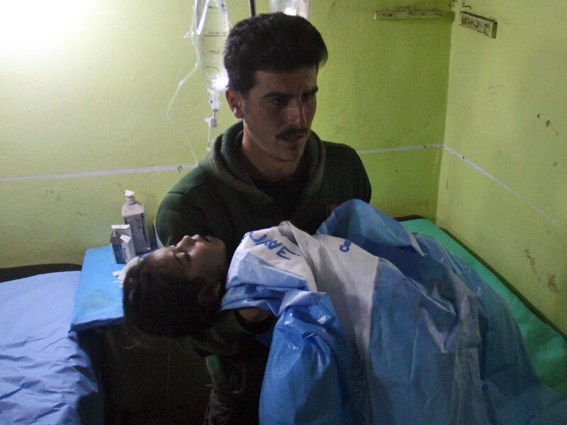 An unconscious Syrian child is carried at a hospital in Khan Sheikhun, a rebel-held town in the northwestern Syrian Idlib province, following a suspected toxic gas attack on April 4, 2017. (AFP/Omar Haj Kadour)
