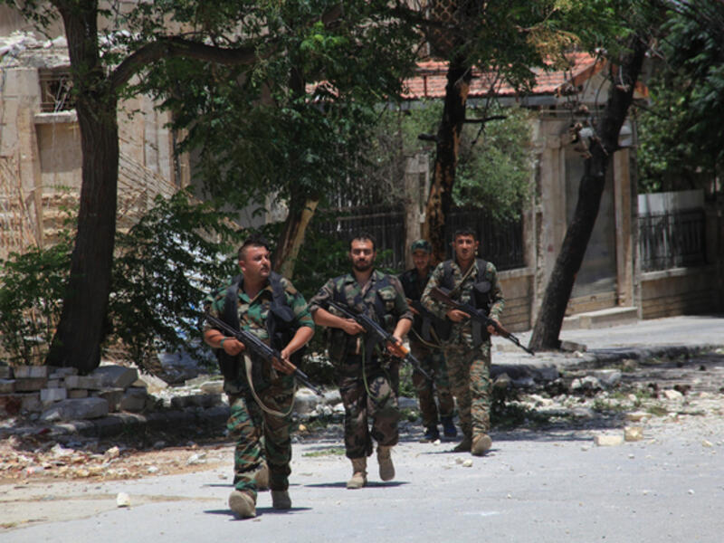 Syrian army soldiers patrol a damaged area of west Aleppo (AFP/File)