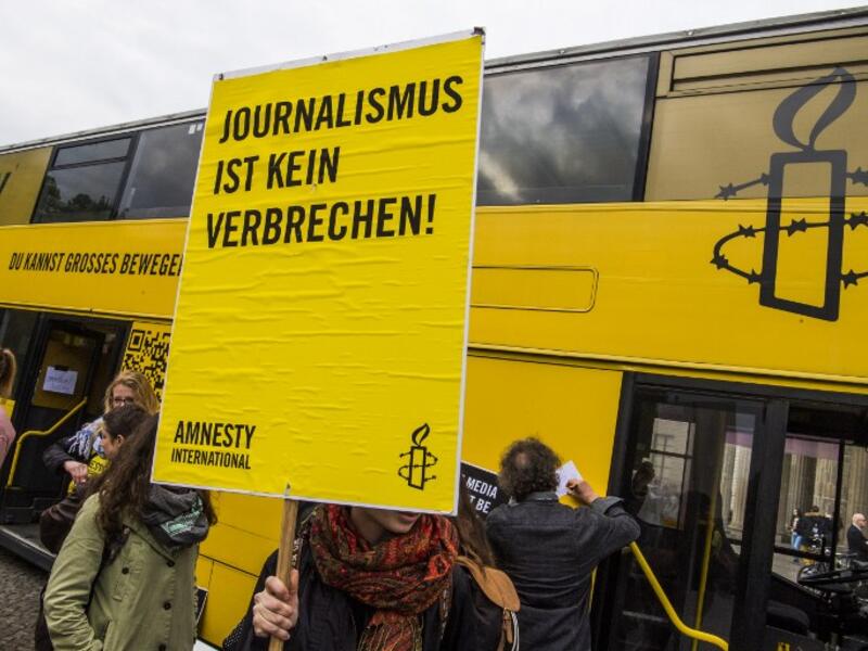 Placard reads "journalism is not a crime" at concert in Berlin on International Press Freedom Day (John Macdougall/AFP)