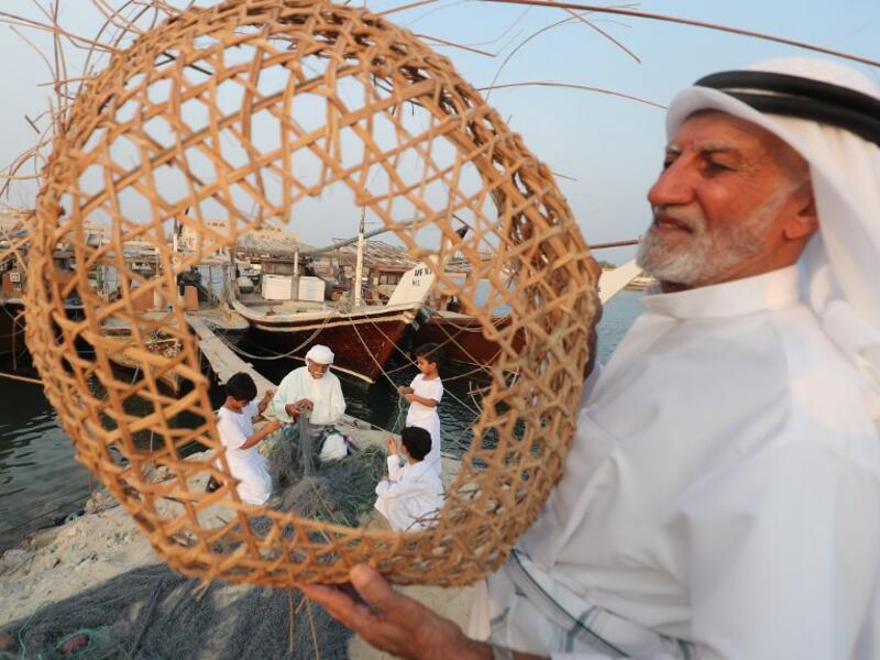 Emiratis train their children on handicraft industries during the Dalma Sailing Festival. (KARIM SAHIB / AFP)