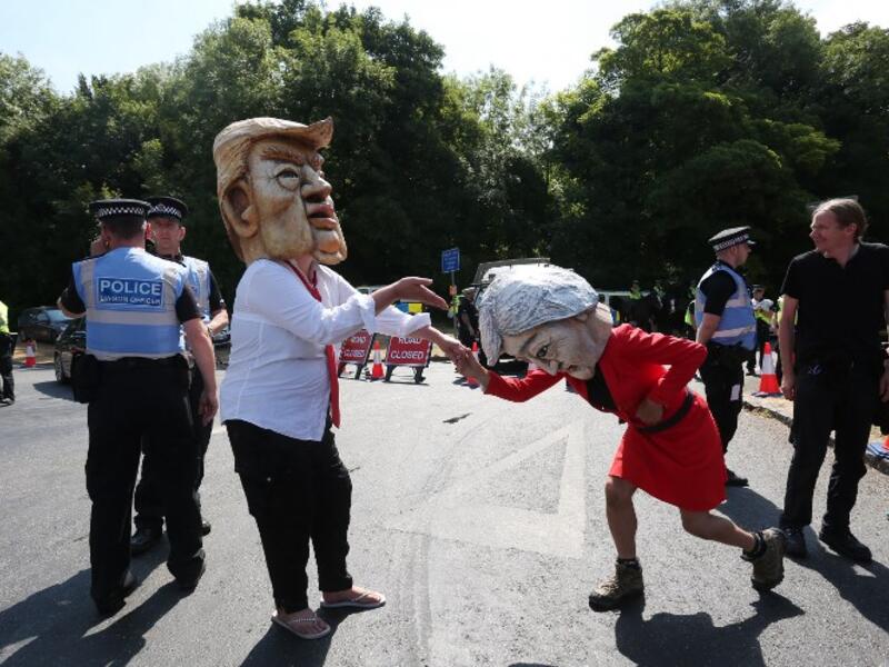 Protesters wearing masks depicting US President Donald Trump (L) and Britain's Prime Minister Theresa May (R) join other protesters against the UK visit of US President Donald Trump demonstrate outside Chequers, the prime minister's country residence, where Trump and May are holding a meeting. (Isabel INFANTES / AFP)