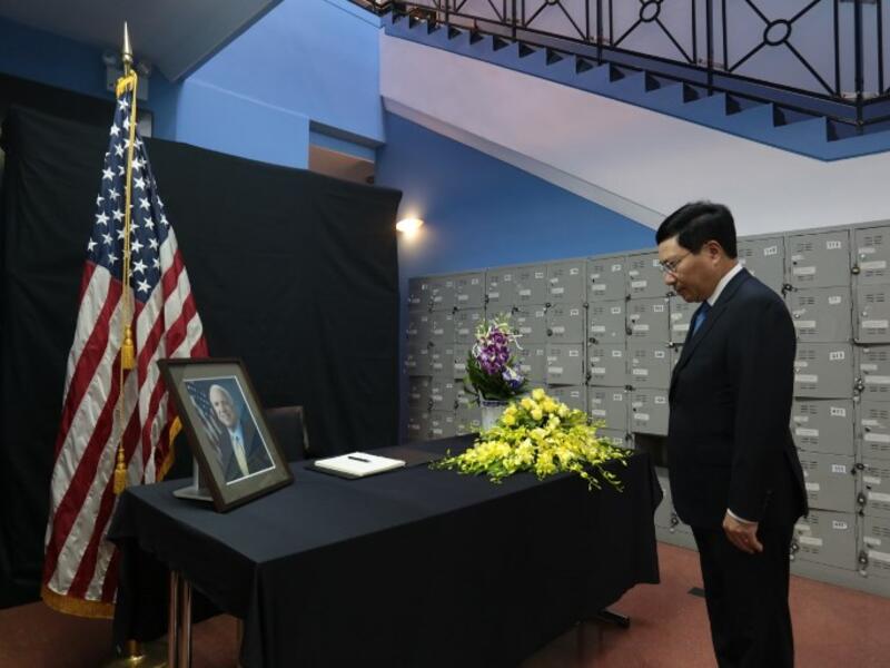 Vietnamese Deputy Prime Minister Pham Binh Minh pays repect to the late US Senator John McCain during a memorial tribute at the US embassy in Hanoi on August 27, 2018.  (Nhac NGUYEN / AFP)