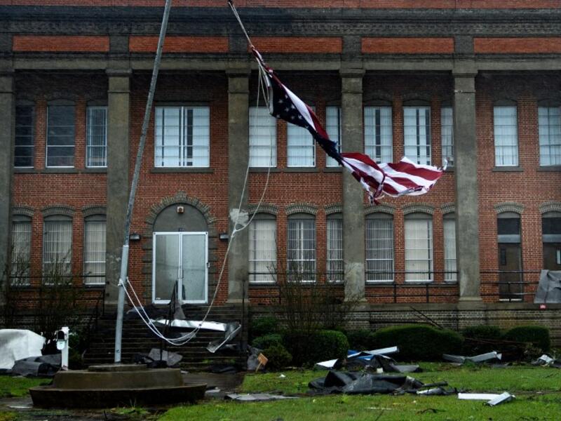An American flag is torn in front of a school during Hurricane Michael October 10, 2018 in Panama City, Florida. (Brendan Smialowski / AFP)