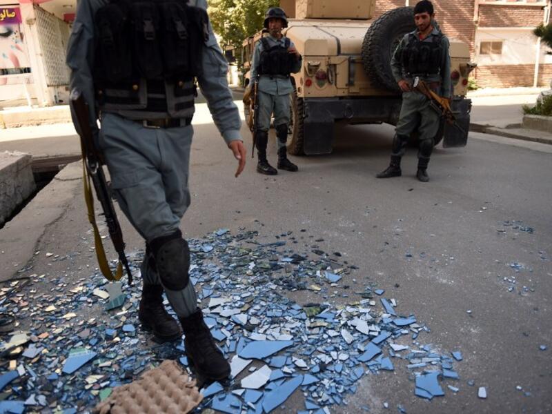 Afghan security forces outside the site of an attack on Care International in Kabul on September 6, 2016. (AFP/Walik Kohsar)