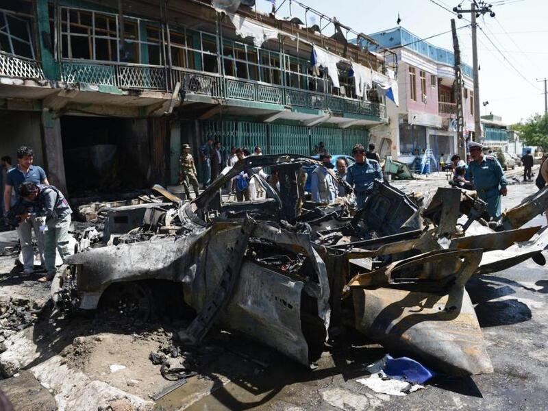 Afghan police walk around a destroyed U.S. military vehicle at the site of a suicide attack in Kabul on May 16, 2013. (AFP/Massoud Hosseini)