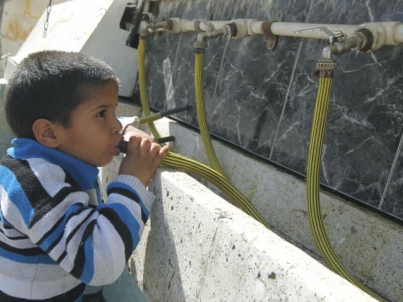 A Palestinian boy drinking water from a clean source in the Gaza Strip. (AFP/File)