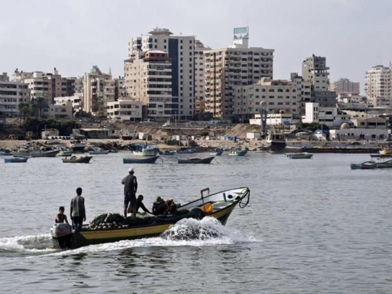 Fishermen ride a small boat into the harbour on August 18, 2014 in Gaza City. (ROBERTO SCHMIDT/AFP) 