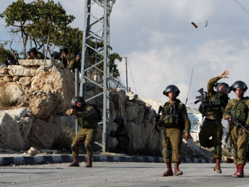 Israeli soldiers throw a flash grenade during clashes with Palestinian demonstrators in the West Bank village of Beit Fajjar, on October 31, 2015 (AFP Photo/Musa Al-Shaer)