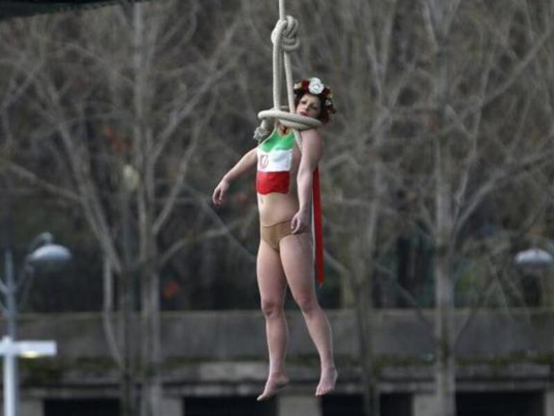 A Femen protester performs a mock hanging off a Parisian bridge (AFP/File)