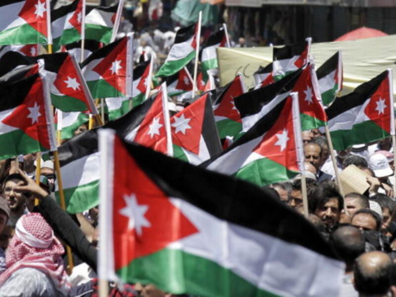 Protesters from the Islamic Action Front and other opposition parties hold up Jordanian national flags and shout slogans demanding political and economic reform, and access to cases of corruption, during a demonstration in Amman on June 14, 2013. [AFP]