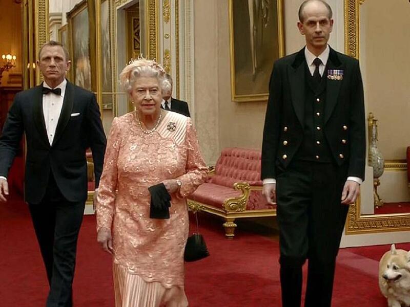 الملكة إليزابيث: خلال حفل افتتاح الألعاب الأولمبية الصيفية في لندن 2012 ظهرت ملكة بريطانيا إليزابيث الثانية في لقطة مع جيمس بوند، الذي وصل إلى القصر الملكي في سيارة أجرة ليرافقها في طائرة مروحية.
