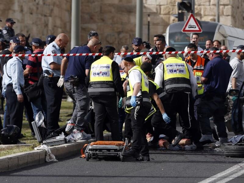 Israeli emergency personnel and security forces gather at the scene of an attack outside Jerusalem's Old City's New Gate on March 9, 2016. (AFP/Ahmad Gharabli)