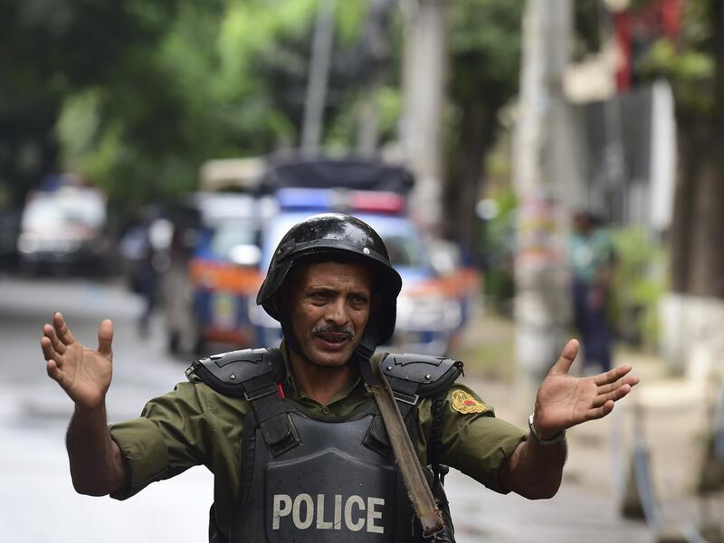 A Bangladeshi police officer gestures during a rescue operation as gunmen take position in a restaurant in the Dhaka’s high-security diplomatic district on July 2, 2016 where several people including foreigners are believed to be trapped. (AFP photo)