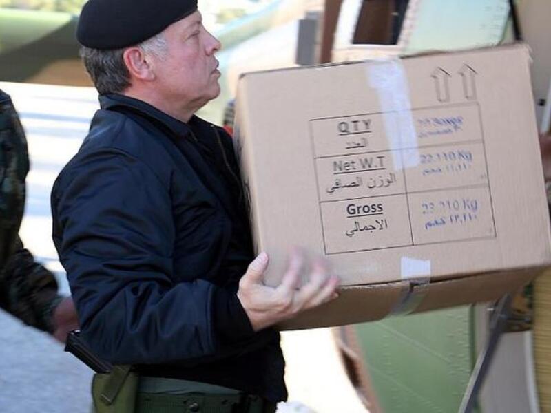King Abdullah of Jordan loading a box containing ready meals onto a helicopter during his visit to the Northern Command in Ajloun, as he follows up on the national effort to deliver services and goods to citizens caught in the snow storms through out the kingdom. [AFP]