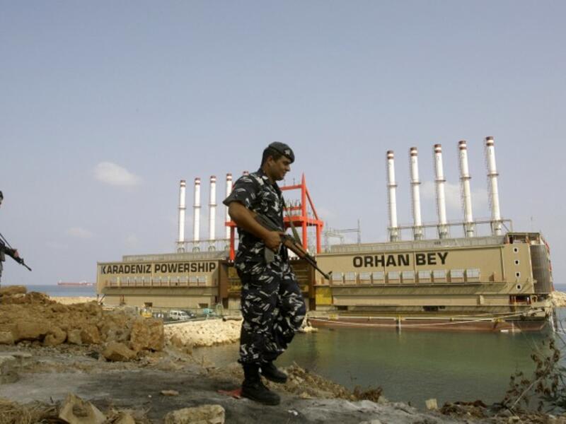 LEBANON, JIYEH : Lebanese police officers guard Turkish local power generating ship Orhan Bey docked in Jiyeh, south of Beirut, on August 13, 2013. AFP PHOTO/MAHMOUD ZAYYAT