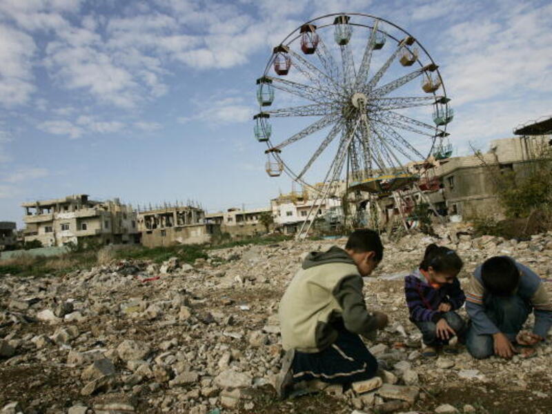  Palestinian children collect stones to be thrown at their friends as they play a 'war' game in the Palestinian refugee camp of Nahr al-Bared, 2009.  JOSEPH EID/AFP/Getty Images)
