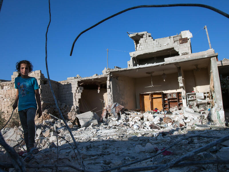A Syrian girl walks next to the debris of her house, after it was targeted by a missile, in the northwestern Syrian province of Idlib on July 18, 2013. (Source: AFP/DANIEL LEAL-OLIVAS)