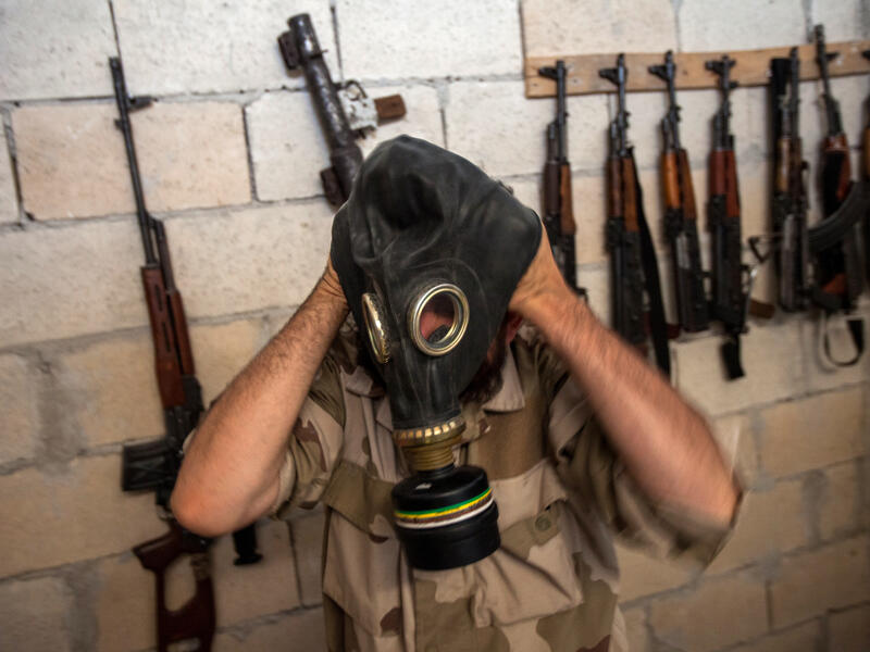 A Syrian rebel tries on a gas mask seized from a Syrian army factory in the northwestern province of Idlib (AFP/DANIEL LEAL-OLIVAS