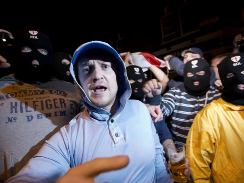 Members of the English Defence League (EDL) wear balaclavas as they gather outside a pub in Woolwich in London on May 22, 2013 after a man believed to be a serving British soldier was brutally murdered nearby in what Prime Minister David Cameron said appeared to be a terrorist attack (Justin Tallis / AFP)