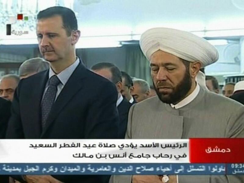 Not dead yet:  Syrian President Bashar al-Assad (L) and Syrian Grand Mufti Ahmed Hassun attend the morning prayer of Eid al-Fitr in Damascus on Thursday shortly after the FSA claimed to have attacked his convoy. (AFP)