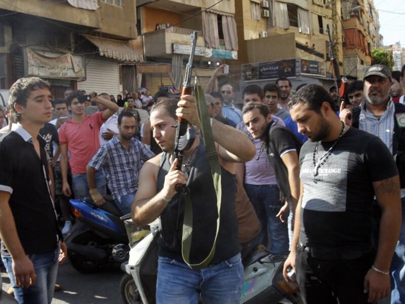 A Lebanese gunman is seen during the funeral procession of Hamad al-Moqdad, one of the Lebanese victims of a car bomb attack that killed dozens in a Beirut stronghold of Shiite group Hezbollah, which backs Syria's embattled president, in the capital on August 16, 2013. (AFP)