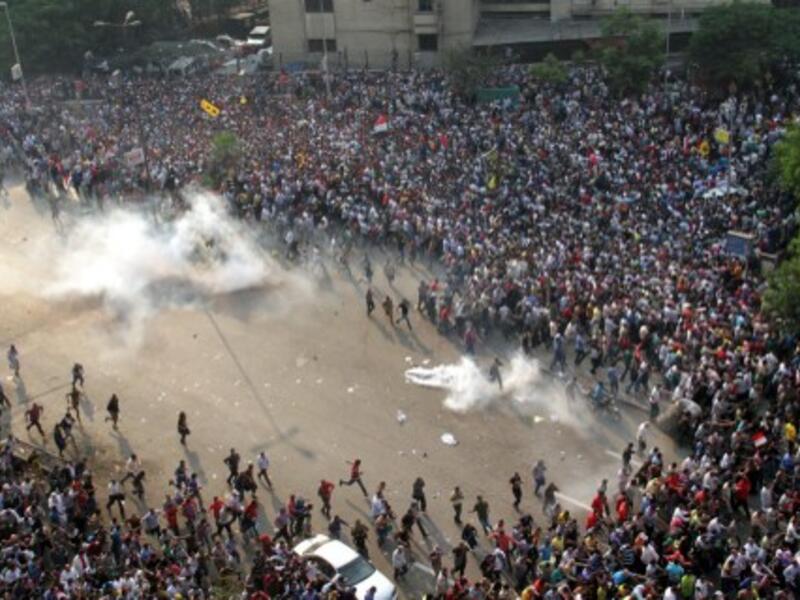 EGYPT, Cairo : Egyptian Muslim brotherhood and supporters of ousted president Mohamed Morsi run for cover from tear gas during clashes with riot police along Ramsis street in downtown Cairo, on October 6, 2013 (AFP)
