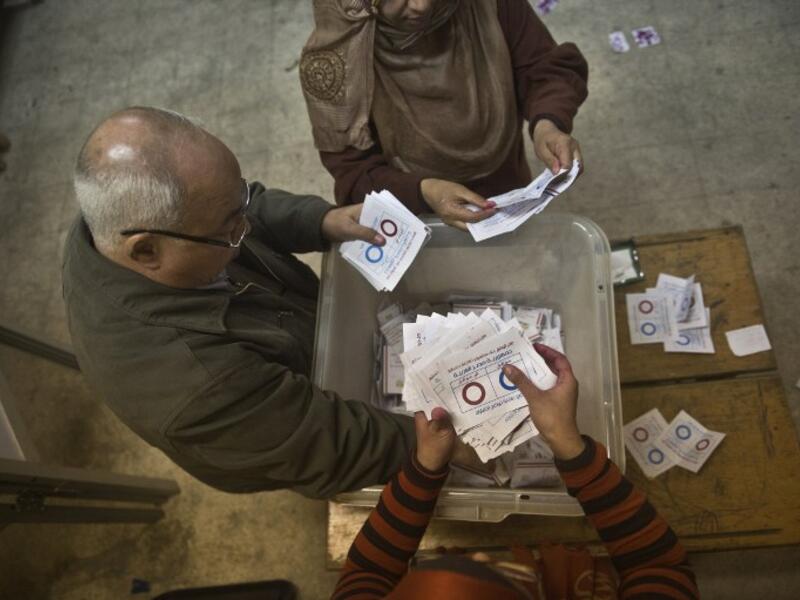 Polling station officials count ballots in the Egyptian capital Cairo on January 15, 2014 at the end of the second day of voting in a referendum on a new constitution. [AFP]