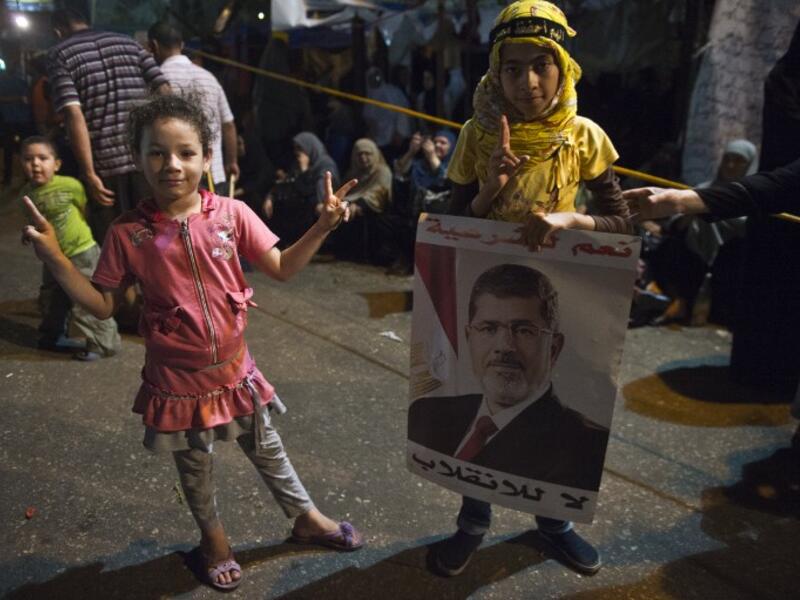 EGYPT, Cairo : Egyptian girls attend with their families supporters of Egypt's deposed president Mohamed Morsi an open sit in outside Rabaa al-Adawiya mosque in Cairo on August 1, 2013. AFP PHOTO / KHALED DESOUKI