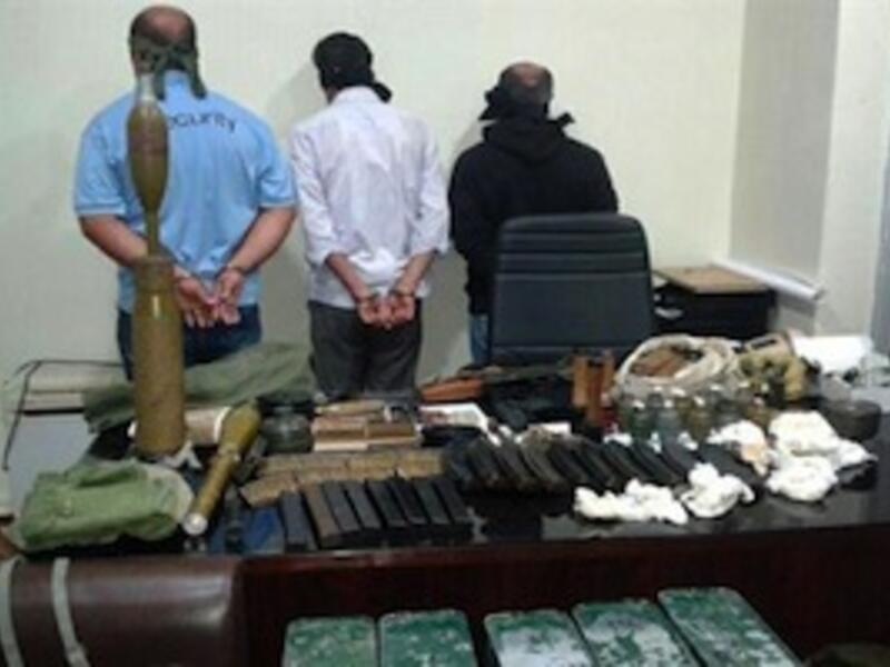 In this picture released by the State Security on Friday, Sept. 20, 2013, blindfolded suspects stand near seized weapons and explosives. (The Daily Star/NNA, HO)