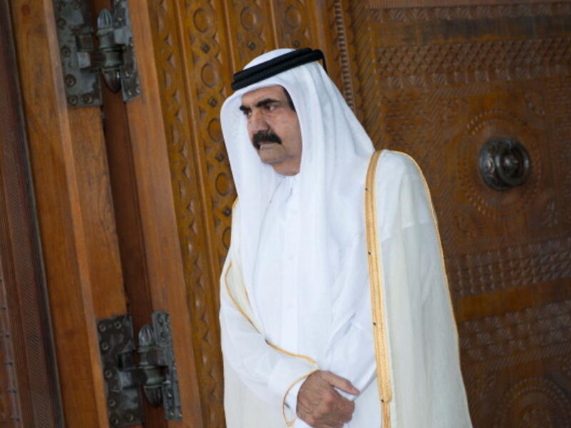 Qatari Emir Sheikh Hamad bin Khalifa al-Thani awaits for France's President Francois Hollande prior to a welcoming ceremony at the Diwan Emiri as part of a two-day official visit in Doha on June 23, 2013 (BERTRAND LANGLOIS/AFP/Getty Images)